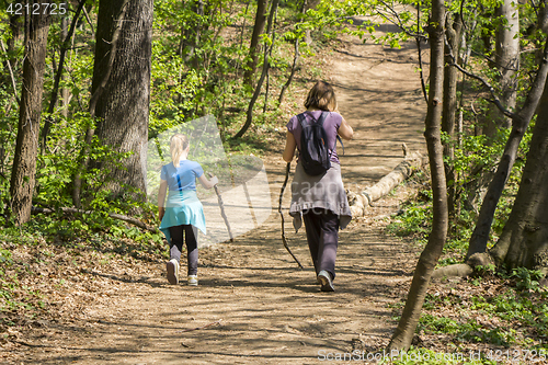 Image of Mother and daughter walking in spring forest