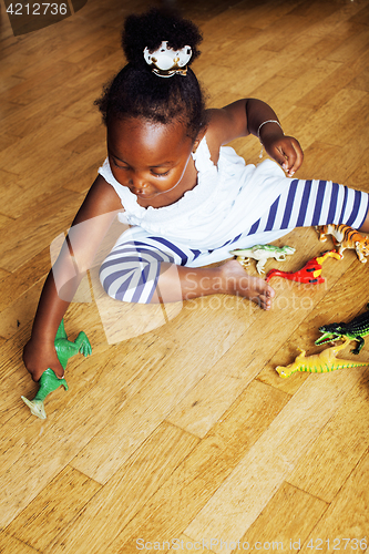 Image of little cute african american girl playing with animal toys at ho