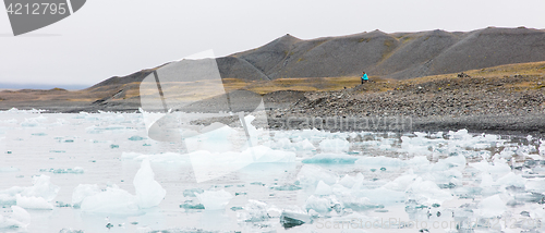 Image of Woman sitting on the beach at Jokulsarlon glacier lagoon - Icela