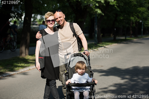 Image of couple with baby pram in summer park