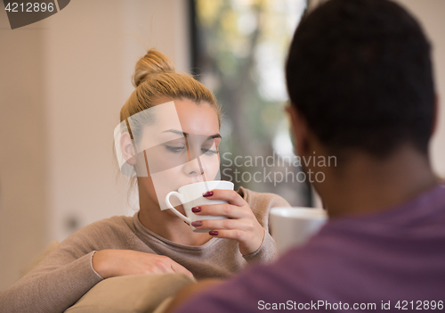 Image of Young multiethnic couple  in front of fireplace