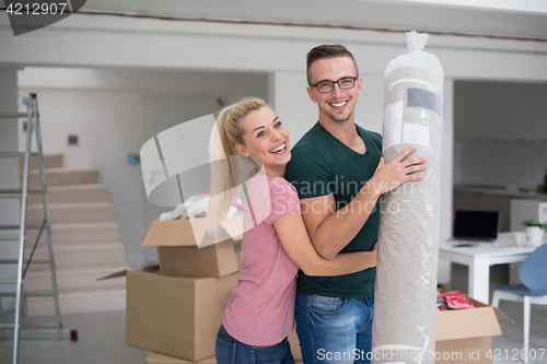 Image of couple carrying a carpet moving in to new home