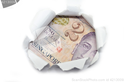 Image of Singapore currency peeking through white paper