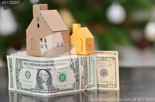 Image of Miniature paper made house stand on  money