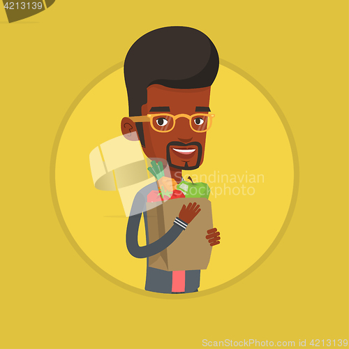 Image of Happy man holding grocery shopping bag.