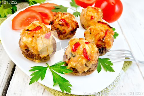 Image of Champignons stuffed with meat and peppers in plate on board