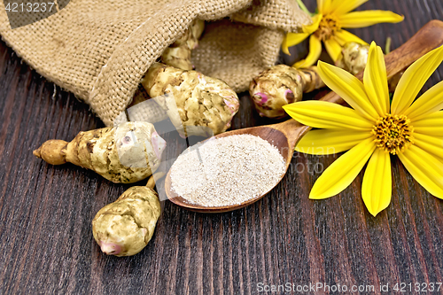 Image of Flour of Jerusalem artichoke in spoon with flower on board