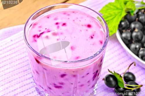 Image of Milkshake with black currants in glass on wooden board