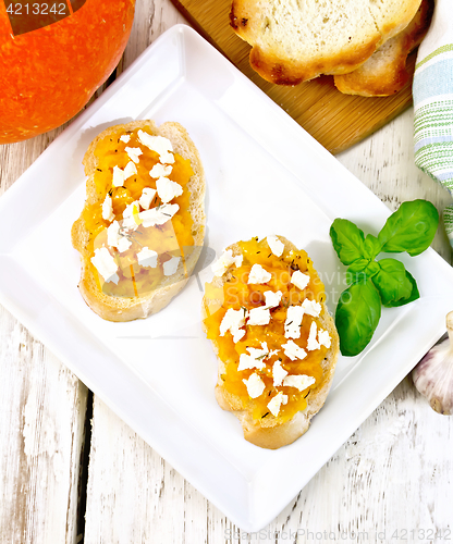 Image of Bruschetta with pumpkin and cheese in plate on board top