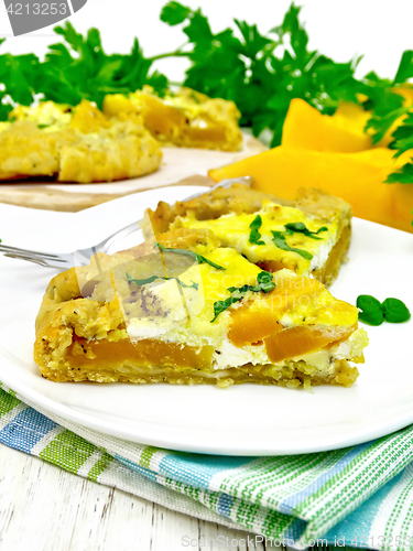 Image of Pie of pumpkin and basil in plate on napkin