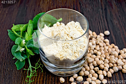 Image of Flour chickpeas in glassful with peas on dark board