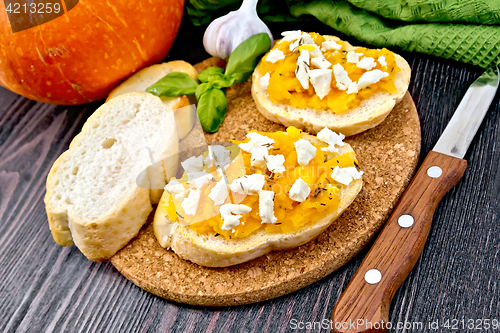 Image of Bruschetta with pumpkin and feta on dark board