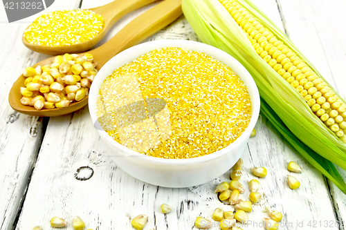 Image of Corn grits in bowl with cobs on board