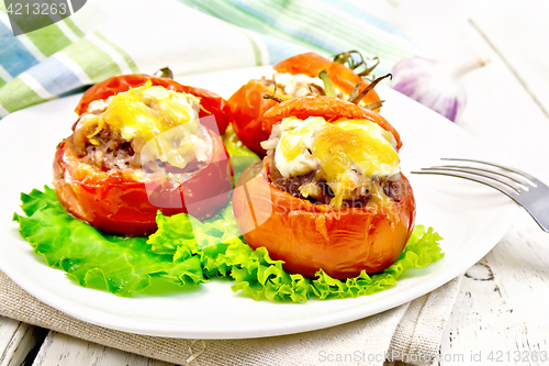Image of Tomatoes stuffed with rice and meat in plate on light board