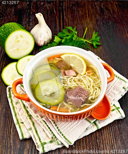 Image of Soup with zucchini and noodles in bowl on napkin