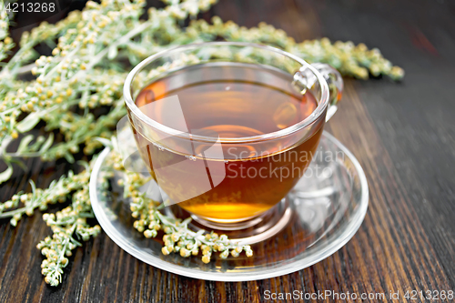 Image of Tea with gray wormwood in glass cup on table