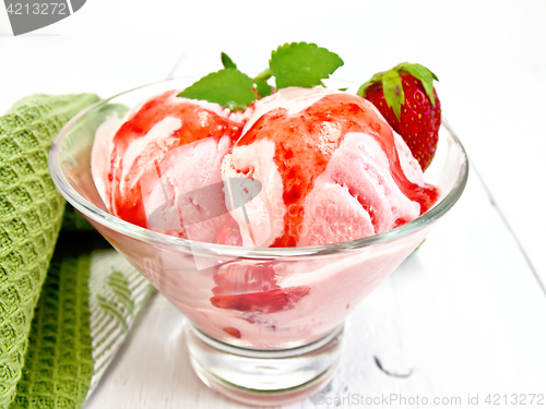 Image of Ice cream strawberry with syrup in glass on light board