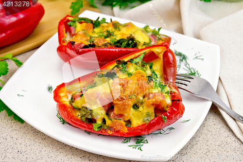 Image of Pepper stuffed with sausage and cheese in white plate on table