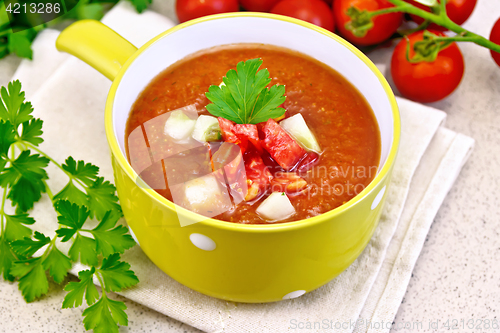 Image of Soup tomato in yellow bowl on stone table