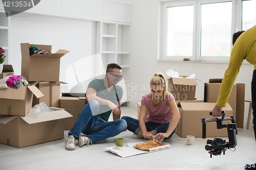 Image of young couple have a pizza lunch break on the floor