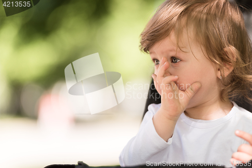 Image of baby girl sitting in the pram