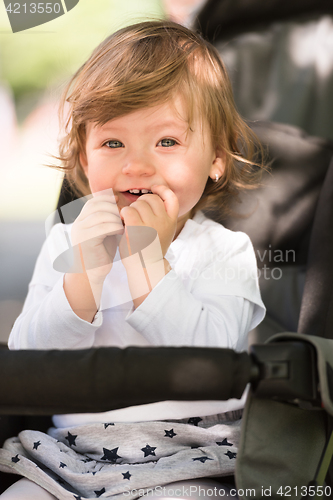 Image of baby girl sitting in the pram