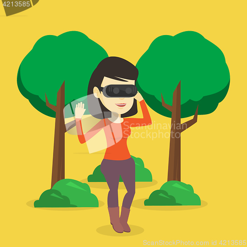 Image of Woman wearing virtual reality headset in the park.