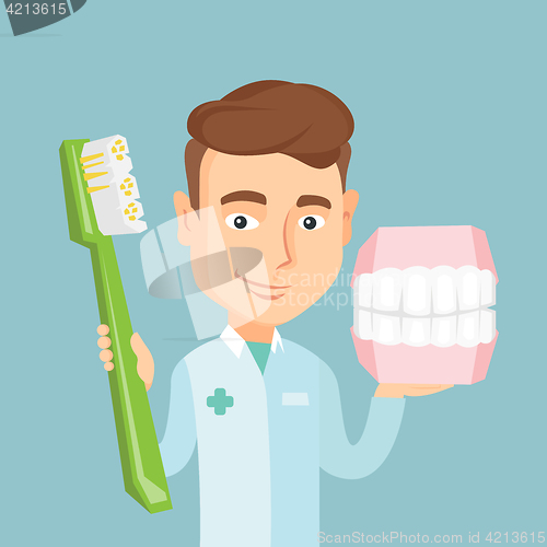 Image of Dentist with dental jaw model and toothbrush.