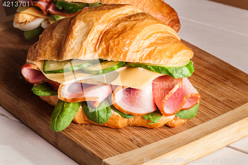 Image of Croissants sandwiches on the wooden cutting board