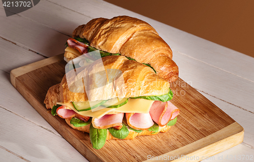 Image of Croissants sandwiches on the wooden cutting board
