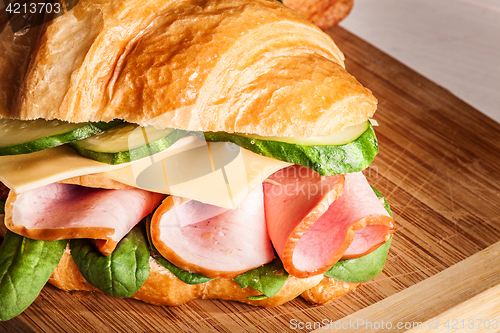 Image of Croissants sandwiches on the wooden cutting board