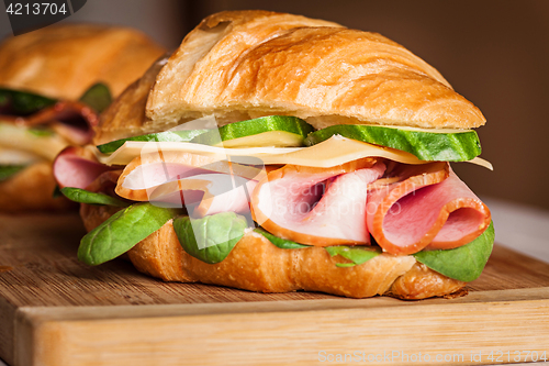 Image of Croissants sandwiches on the wooden cutting board