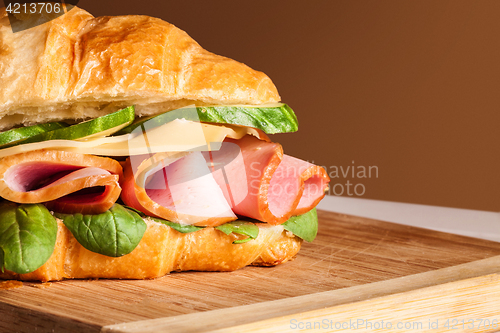 Image of Croissants sandwiches on the wooden cutting board