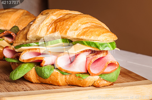 Image of Croissants sandwiches on the wooden cutting board