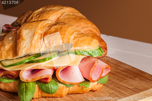 Image of Croissants sandwiches on the wooden cutting board