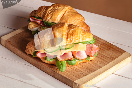 Image of Croissants sandwiches on the wooden cutting board