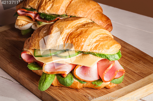 Image of Croissants sandwiches on the wooden cutting board