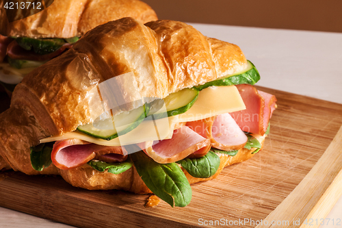 Image of Croissants sandwiches on the wooden cutting board