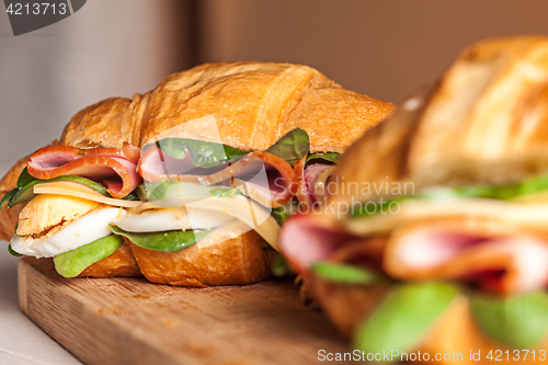 Image of Croissants sandwiches on the wooden cutting board