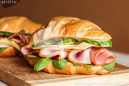 Image of Croissants sandwiches on the wooden cutting board