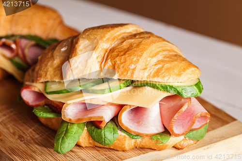 Image of Croissants sandwiches on the wooden cutting board