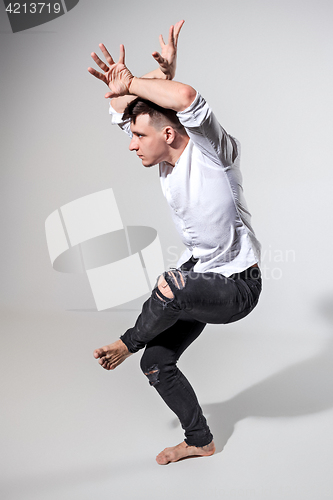 Image of The young man dancing on gray