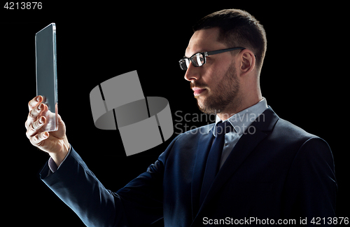 Image of businessman in suit with transparent tablet pc