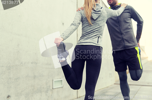 Image of close up of couple stretching legs outdoors