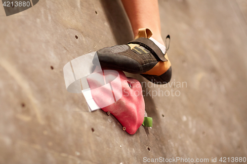 Image of foot of woman on indoor climbing gym wall hold