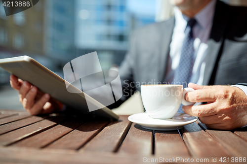 Image of senior businessman with tablet pc and coffee