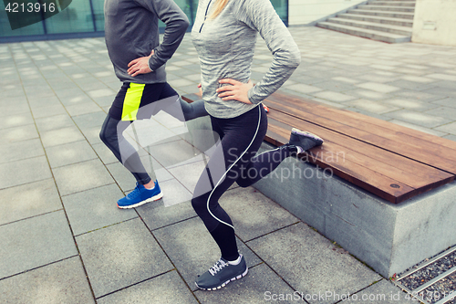 Image of close up of couple doing lunge exercise on street