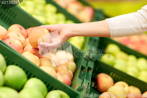 Image of hand with apples at grocery store