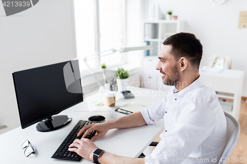 Image of businessman typing on computer keyboard at office