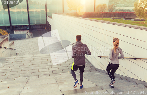 Image of couple running downstairs on city stairs